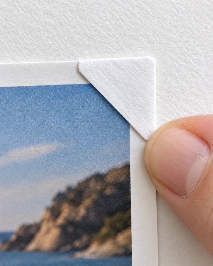 Placing a printed photo into a paper photo corner